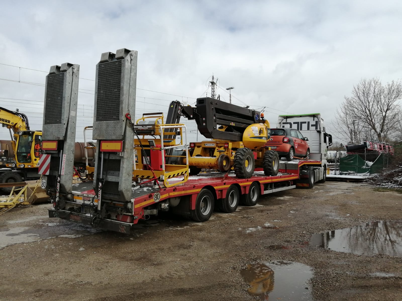 Verladung eines 2-Wege Hubarbeitsbühne auf einem Tieflader.